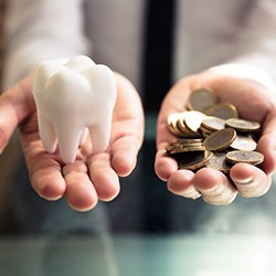 a person holding a tooth in one hand and money in the other