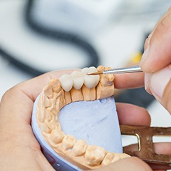 A lab technician working on dental crowns
