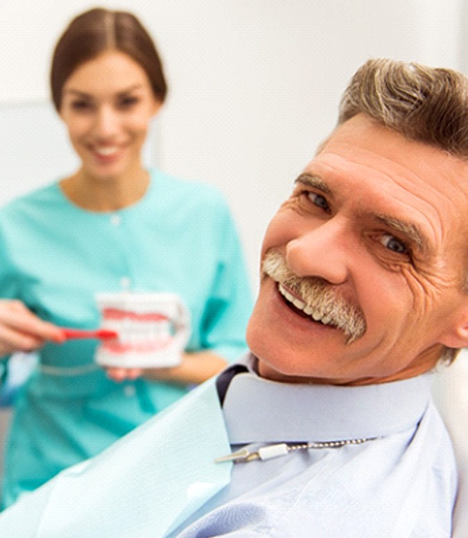 man smiling after getting dentures in Englewood