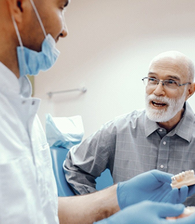 Dentist in Englewood talking to elderly man about dentures