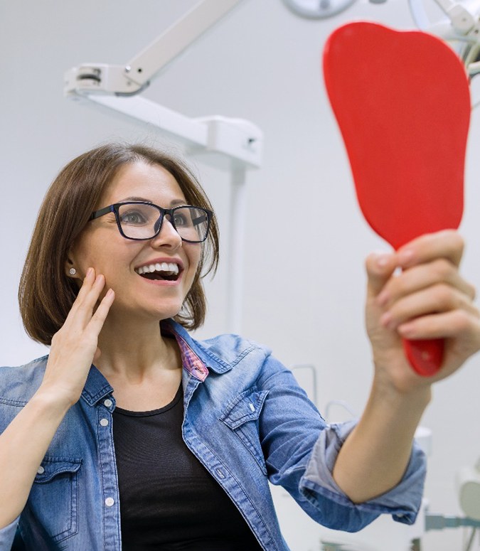 A woman admiring her new dental implants