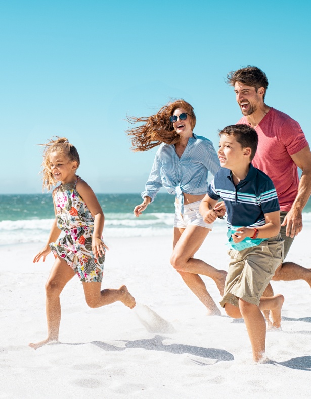 Mother father and two children on the beach after family dentistry visit