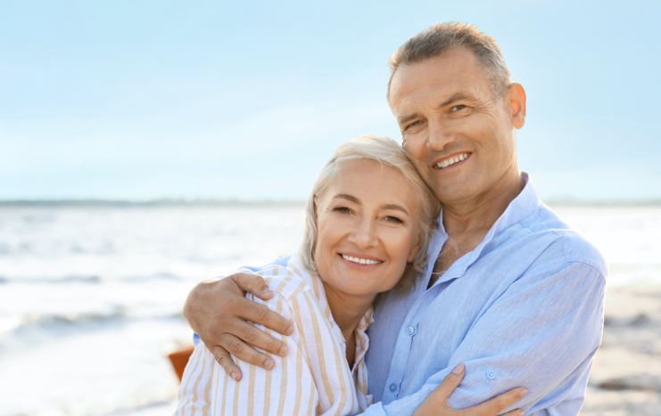 Man and woman with healthy smiles after orthodontic treatment