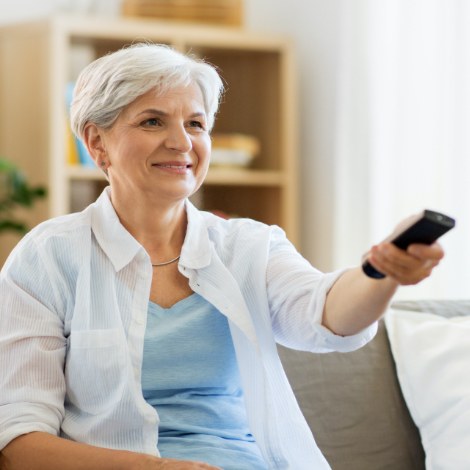Older woman holding a television remote control