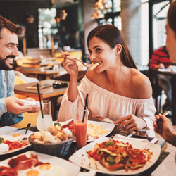 Group of friends smiling while eating at restaurant