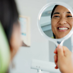 Woman smiling at reflection in mirror