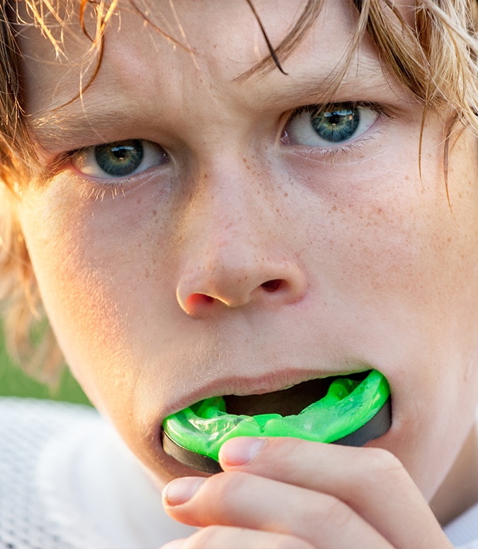 Teen boy placing athletic mouthguard