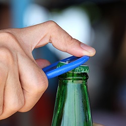 Man opening bottle with bottle opener