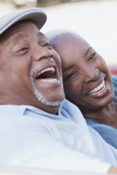 Man and woman laughing after receiving dental services