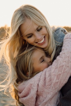 Mother giving her daughter a hug after children's dentistry visit