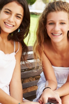 Teen girls smiling one of them has traditional braces