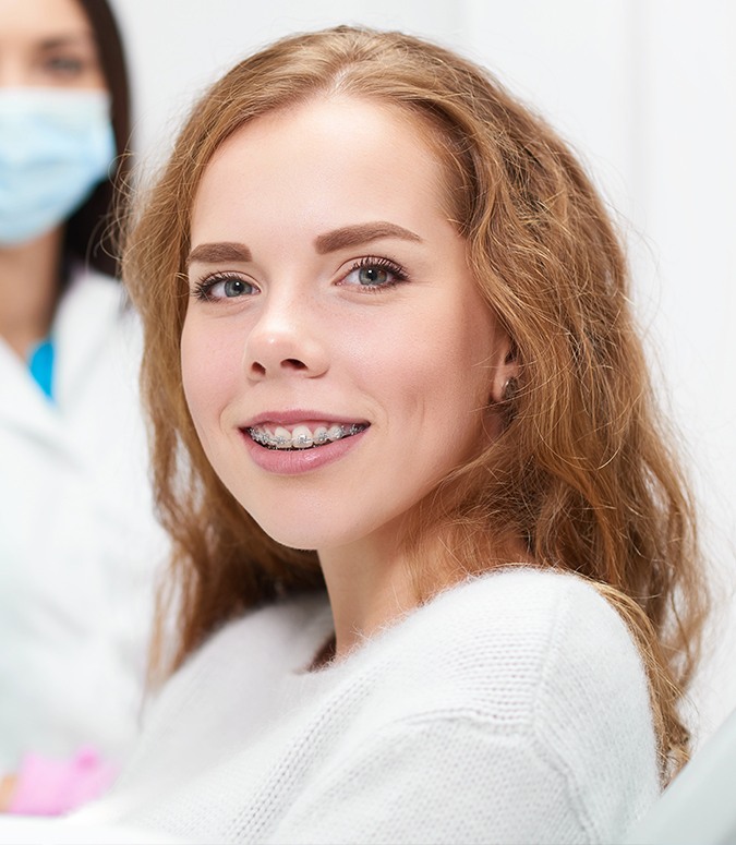 Young woman with traditional orthodontics smiling